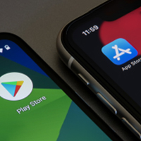 Two smartphones side-by-side, one showing Google Play Store and the other Apple App Store icons—your perfect personal finance app might be just a download away on either platform.